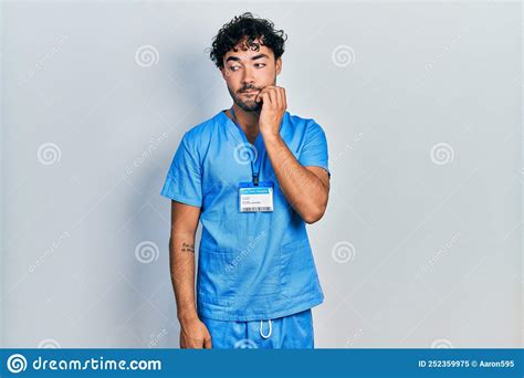 Young Hispanic Man Wearing Blue Male Nurse Uniform Looking Stressed And