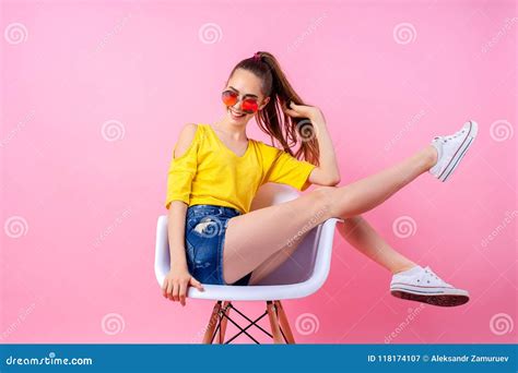 Playful Teenage Girl Sitting In Chair With Legs Raised Stock Image