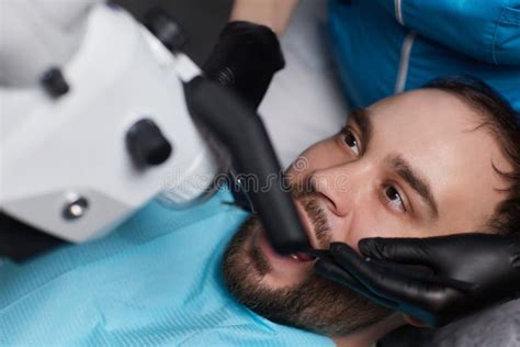 The Dentist Treats His Patientand X27s Teeth With A Microscope The