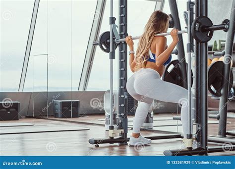 beautiful fitness girl doing squats on smith machine at the gym stock image image of adult