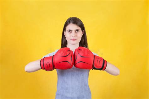 Young Woman With Red Boxing Gloves Stands Ready In A Fighting Stance