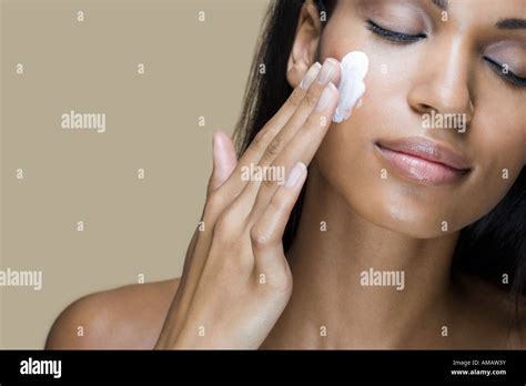 A Woman Rubbing Moisturizer Into Her Skin Stock Photo Alamy