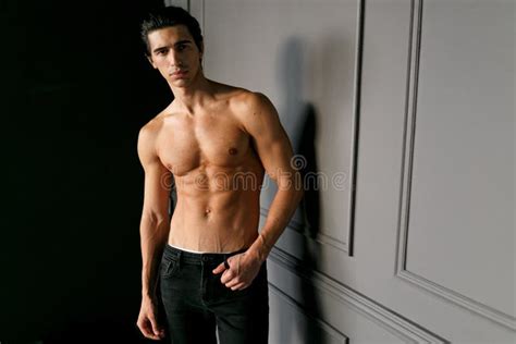 A Male Model Shirtless And Suntanned Looking At Camera Showing Six