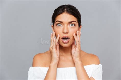 Portrait Of Shocked Pretty Young Woman Touching Her Face Stock Photo