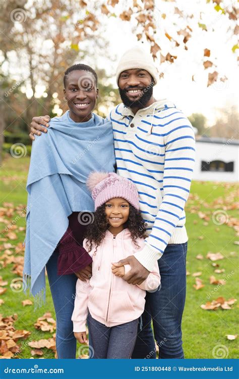 Vertical Image Of Happy African American Parents And Daughter Posing At