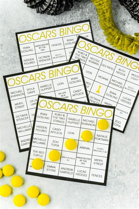 Three Oscars Bingo Game Cards With Yellow And Black Pom Poms On Them