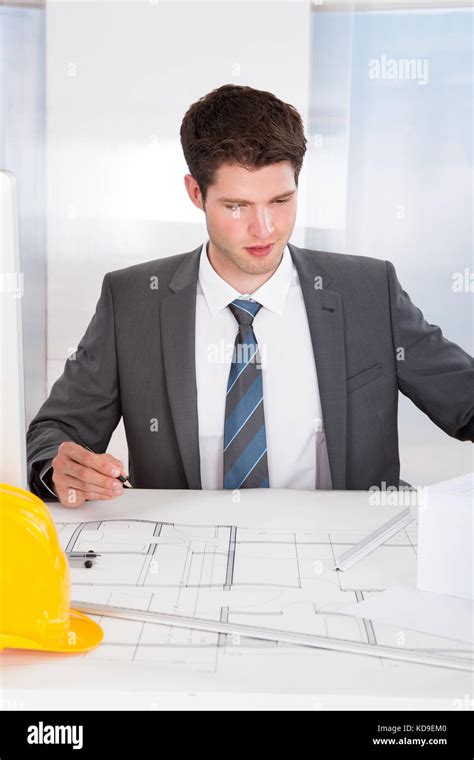 Portrait Of A Young Architect Drawing Plan On Blueprint Stock Photo Alamy