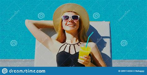 Summer Portrait Of Happy Relaxing Young Woman Lying On A Deck Chair With Cup Of Juice On A Pool