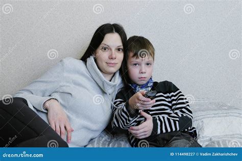 Watching Tv Lying On The Couch Mom And Son Watch Tv Together Son Switches Channels Stock