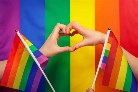 mano haciendo un signo de corazón con orgullo gay lgbt bandera del arco iris foto premium