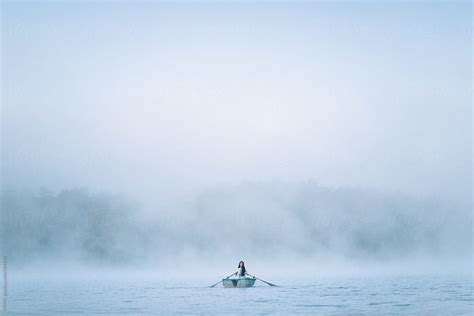 Woman Rows In Rowboat Through The Early Morning Fog By Stocksy Contributor Howl Stocksy