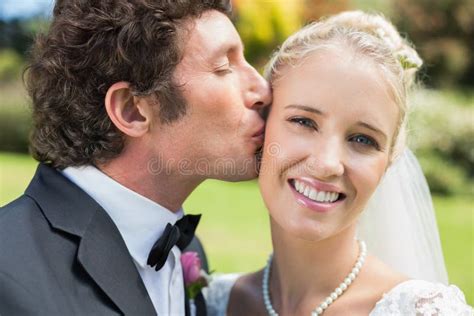 Groom Kissing His Pretty Blonde Wife On The Cheek Stock Image Image