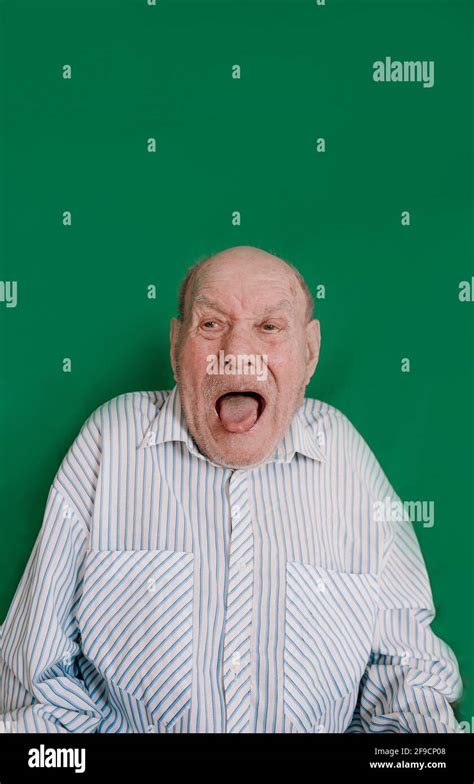 Large Portrait Of A Crazy Old Man On An Isolated Green Background Stock