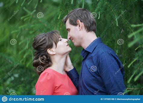 Pretty Caucasian Love Couple Walking In The Green Summer Park Having Smiles Kisses And Hugs