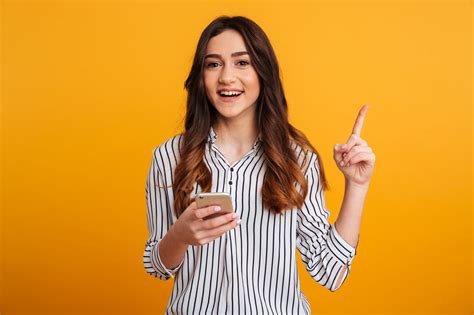 Portrait Of An Excited Young Girl Holding Mobile Phone Linkideia