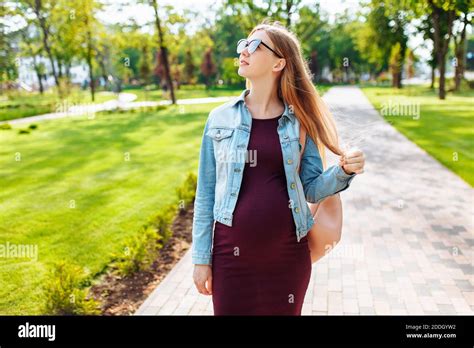 Beautiful Pregnant Girl Student In Sunglasses Walks In The Park After