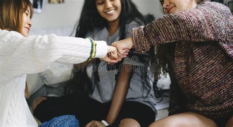 Teenage Girls In A Bedroom Fist Bumping Friendship Concept Stock Image
