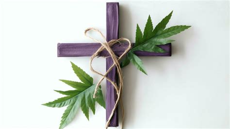 A Christian Wooden Cross Crucifix Sign With Green Palm Leaves As