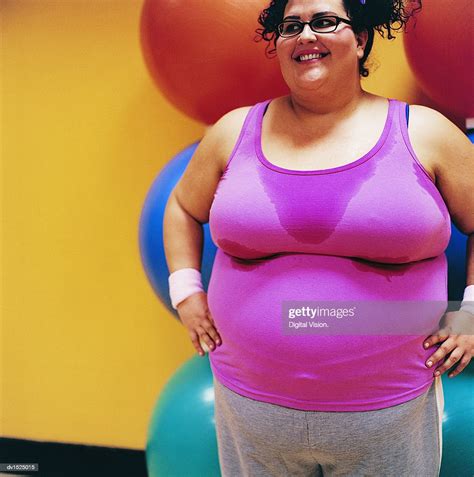 Smiling Overweight Woman Standing In The Gym With Her Hands On Her Hips