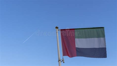 National Flag Of United Arab Emirates On A Flagpole In Front Of Blue