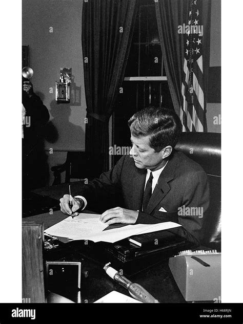 President John F Kennedy Signs Legislation In The Oval Office At The