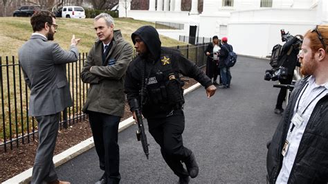 A Secret Service Officer Hurries Past Reporters After A Vehicle Struck