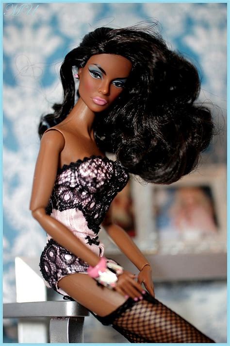 A Barbie Doll Is Sitting On A Table With Her Hair Blowing In The Wind