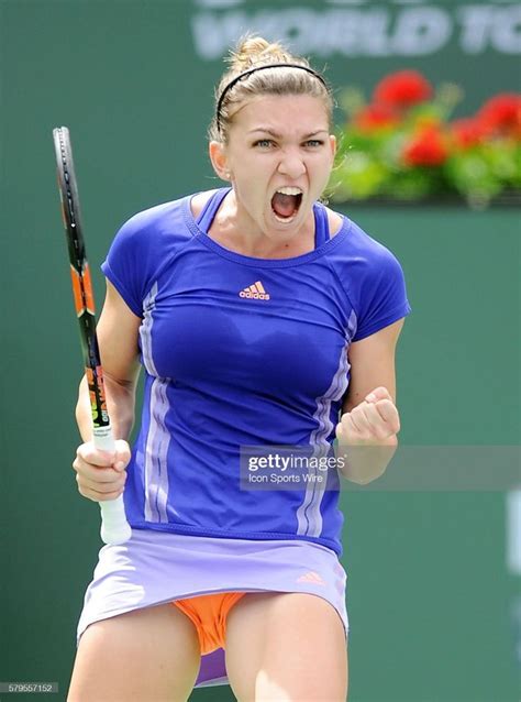 A Woman Holding A Tennis Racquet In Her Hand And Yelling At The Camera
