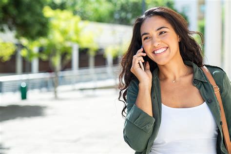 Young Latin Woman Talking On Mobile Phone And Looking Away Successful