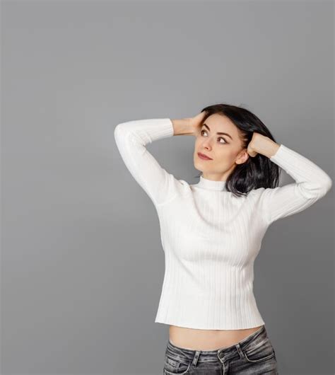 Premium Photo Pretty Woman In A White Sweater Looks At The Camera