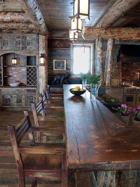 An Old Log Cabin Kitchen With Wooden Tables And Chairs In The Center