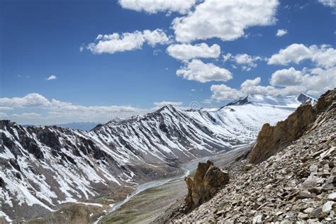 Sharp Snow Covered Mountain Ridge With River And Green Valley On Bottom