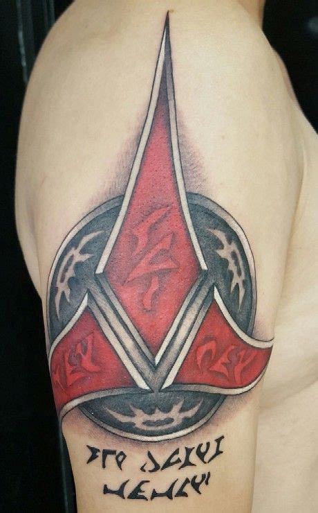 A Man With A Red And Black Tattoo On His Arm