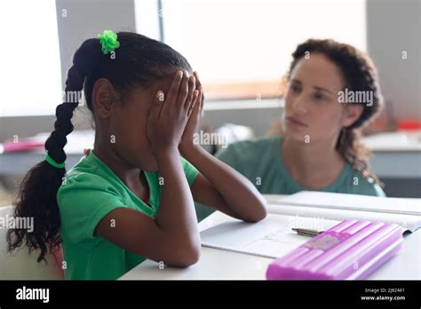 Caucasian Young Female Teacher Consoling Sad African American