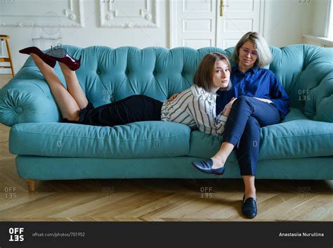 Lesbian Couple Spend Their Time Lying On The Couch Together At Home Stock Photo OFFSET