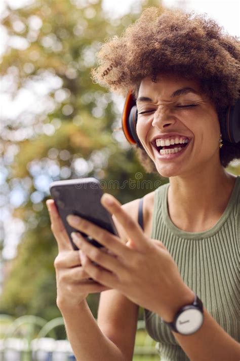 Young Woman Outdoors Wearing Wireless Headphones Streaming Show From