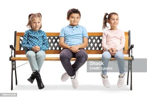 One Boy And Two Girls Sitting On A Bench Stock Photo Download Image