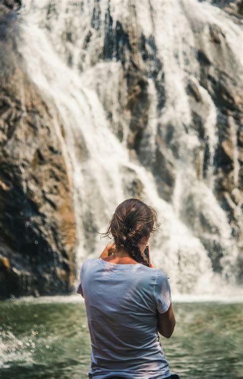 Woman Standing In Front Of Waterfall Photo Free Waterfall Image On
