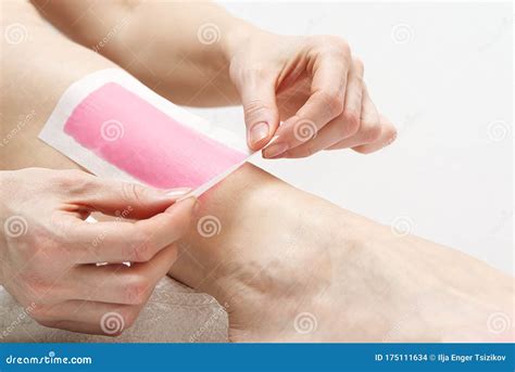 woman using pink wax strips beautiful woman doing depilation for her legs with waxing isolated