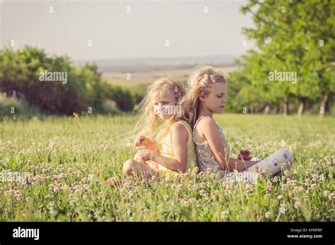 Friends In The Spring Meadow Sitting Together Stock Photo Alamy