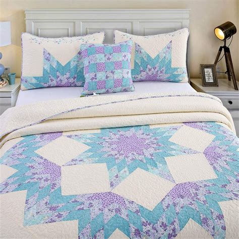 A Bed With Blue And White Quilts On It