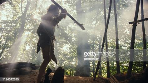 Primeval Caveman Wearing Animal Skin Holds Stone Tipped Spear Stands At