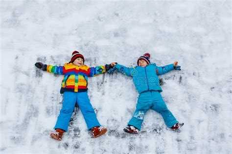 Two Little Kid Boys Making Snow Angel In Winter Stock Image Image Of