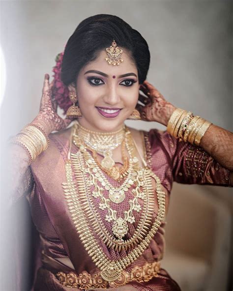 A Woman In A Bridal Outfit Posing For The Camera With Her Hands On Her Head