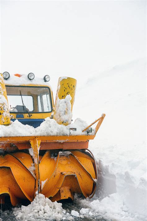 A Snow Plow Tractor Clearing The Snow On The Roads From A Winter Storm