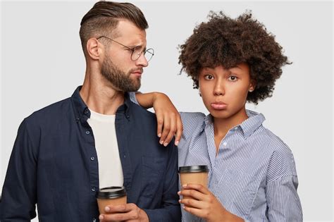 Free Photo Studio Shot Of Puzzled Interracial Couple Have Coffee Break