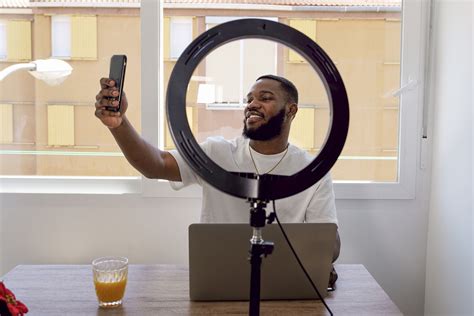 Smiling Vlogger Taking Selfie Through Smart Phone By Laptop At Home Infogram