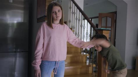 Portrait Of Caucasian Teenage Girl Ignoring Little Boy Fighting With