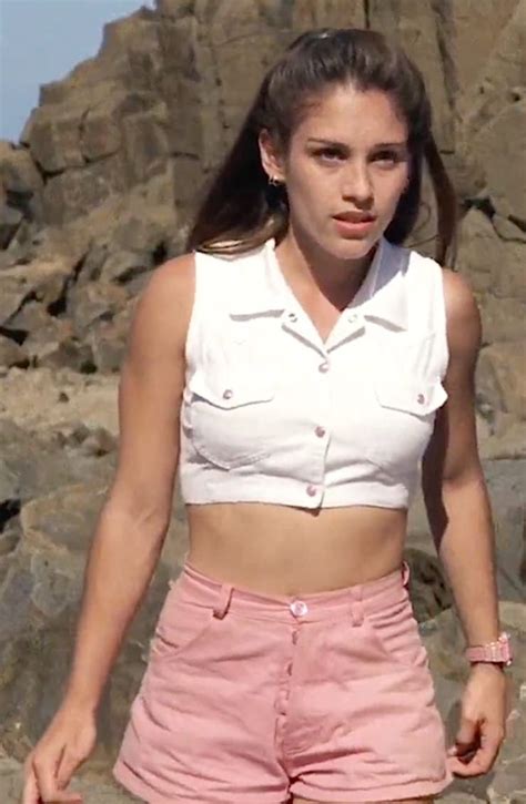 A Woman In Pink Shorts Standing Next To Some Rocks