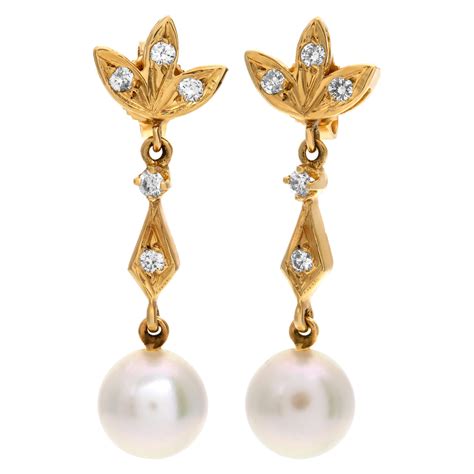 Delicate dangling pearl earring with diamond accents set on 14k yellow
